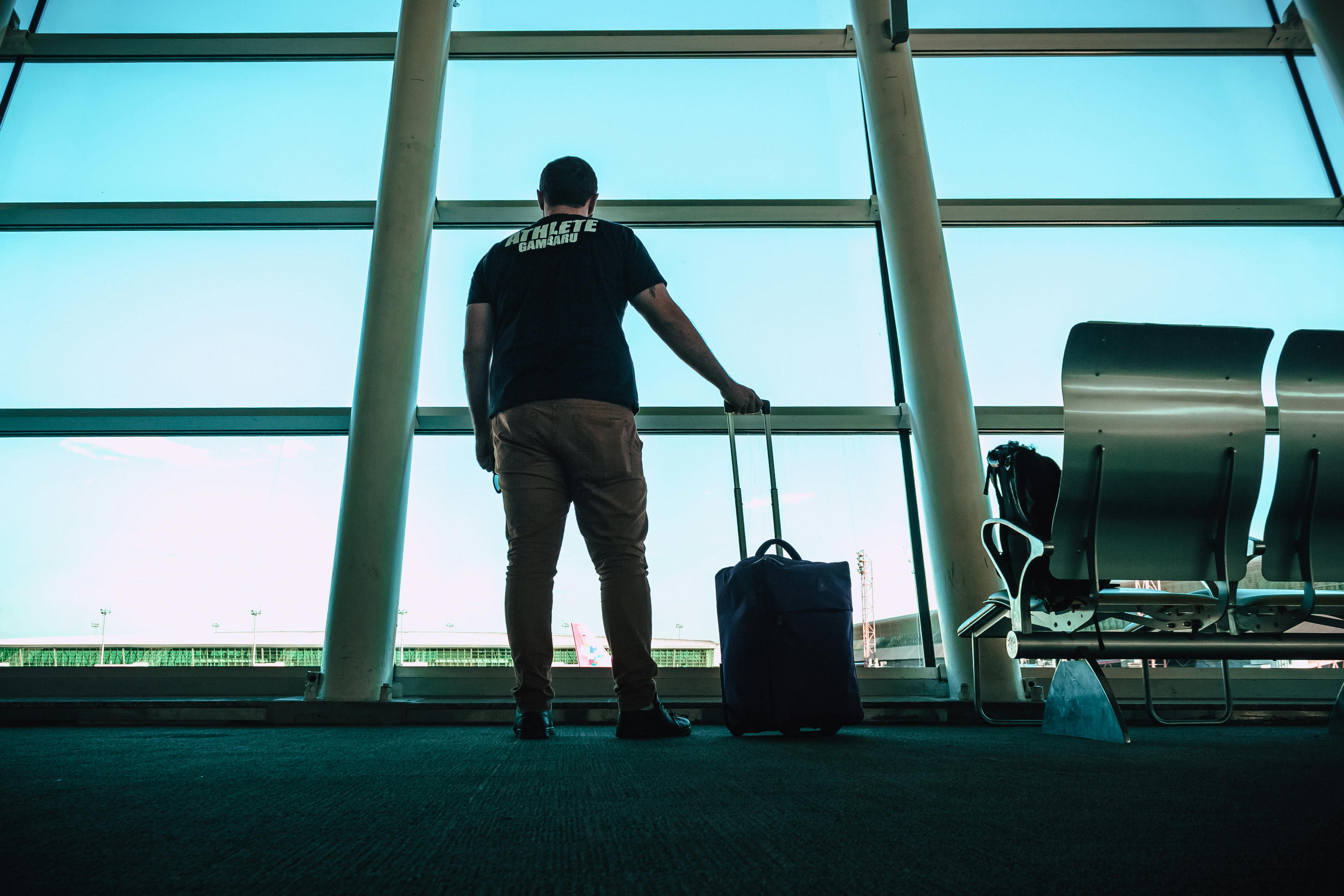 man standing with suitcase